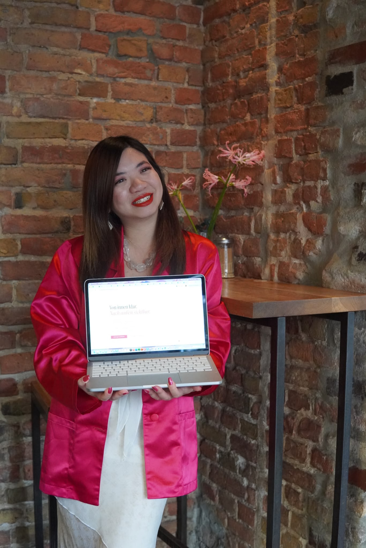 Bao Ngoc Cao mit Laptop und ihrer Webseite in der Hand